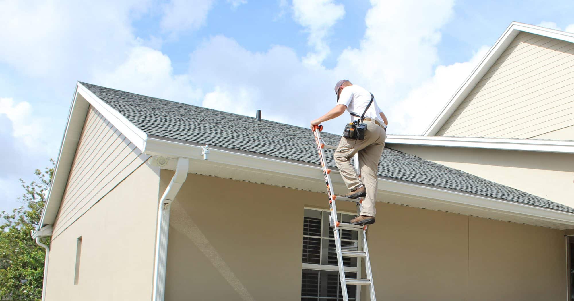 Man climbing a ladder to inspect a roof