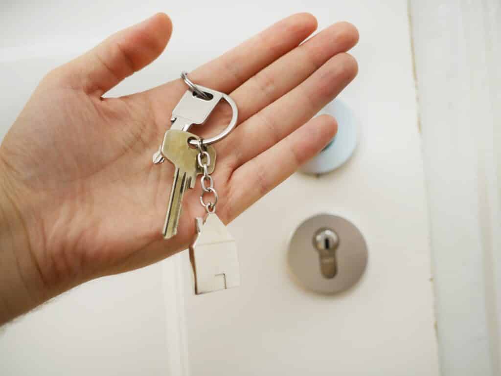 hand holding house keys in front of door