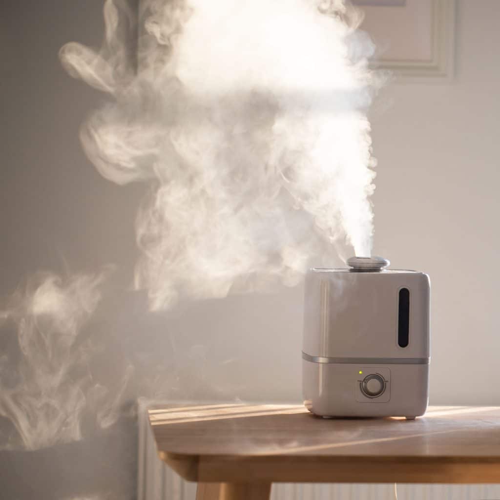 A humidifier sitting on a table inside a home, used to raise the humidity
